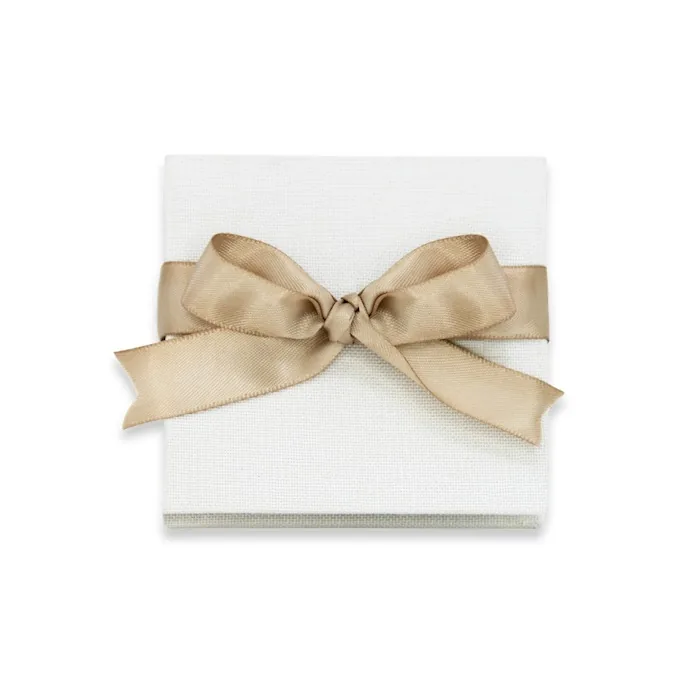 Fold, the accordion brag book, closed, cream linen cover tied with a ribbon and bow
